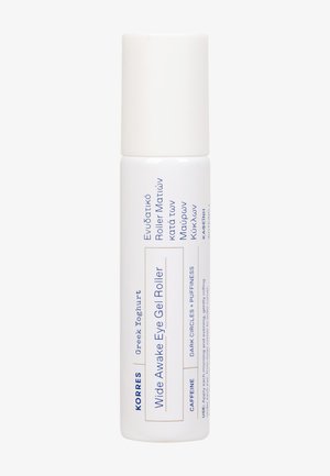 Roll-on gel pour les yeux Korres Wide Awake avec caféine, yaourt grec, et instructions contre les cernes et les poches, contenant cylindrique blanc.