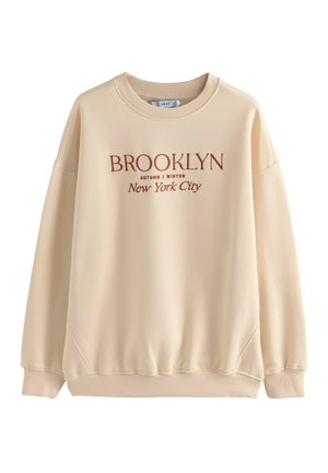 Beige Sweatshirt mit Rundhalsausschnitt, schmaler Schulterpartie und gerippten Bündchen. Mit rotbraunem Text: „BROOKLYN HERBST/WINTER New York City.“