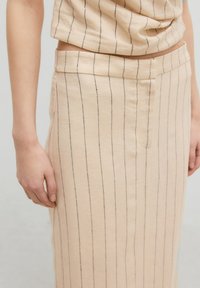 Beige Rock mit vertikalen schwarzen Streifen, mit glatter Textur, Bund und einem seitlichen Schlitz. Der Stoff hat eine natürliche, gewebte Optik.