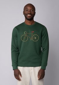 Grüner Sweatshirt mit einem Fahrrad-Design in Braun und Orange. Das Design umfasst einen runden Halsausschnitt und gerippte Bündchen für einen taillierten Look.
