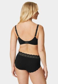 Set di reggiseno nero e mutandine abbinate caratterizzato da un tessuto morbido, spalline regolabili e un bordo in pizzo sulla vita con bordi scallop.