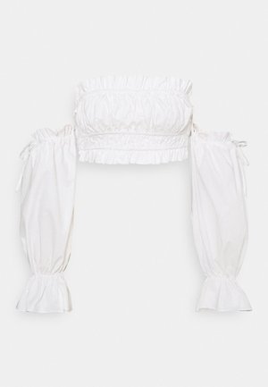 Crop top blanc épaules dénudées avec bords à volants et longues manches bouffantes, resserrées aux poignets et aux épaules par des liens.
