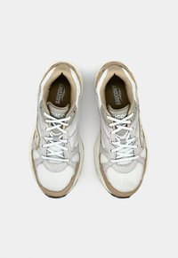 Lys grå sneakers med mesh og semsket skinnpaneler, hvite lisser og en beige gummisåle. Tungen har "Saucony"-logoen.