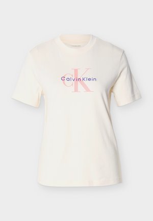 Kreminės spalvos trumpomis rankovėmis medvilniniai marškinėliai su mėlynomis ir rožinėmis raidėmis „Calvin Klein“ bei stilizuotu „ck“ logotipu centre.