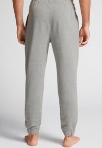Comfortabele grijze sweatpants met een relaxte pasvorm, elastische tailleband, zijzakken en cuffed enkels, gemaakt van zacht materiaal.