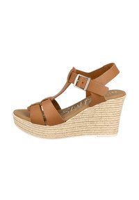 Sandalia de cuña de piel marrón con dos correas delanteras y una correa en el tobillo ajustable. Textura de yute trenzado en el talón de la cuña. Diseño de punta redonda.