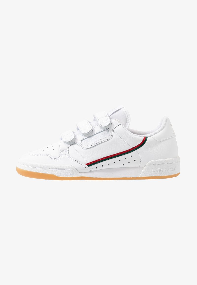 White leather sneaker with three Velcro straps, red and green accent stripe, perforated design, and gum rubber sole. Features Adidas branding.