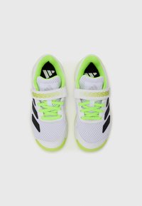Scarpe da ginnastica bianche con accenti neri, tomaia in rete, lacci verde lime e una fascetta in Velcro con un design a fantasia. Costruzione leggera.