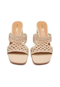 Chanclas de tejido beige con dos amplias correas trenzadas y un diseño de punta cuadrada. Plantilla suave de color claro con un detalle de marca mínimo.