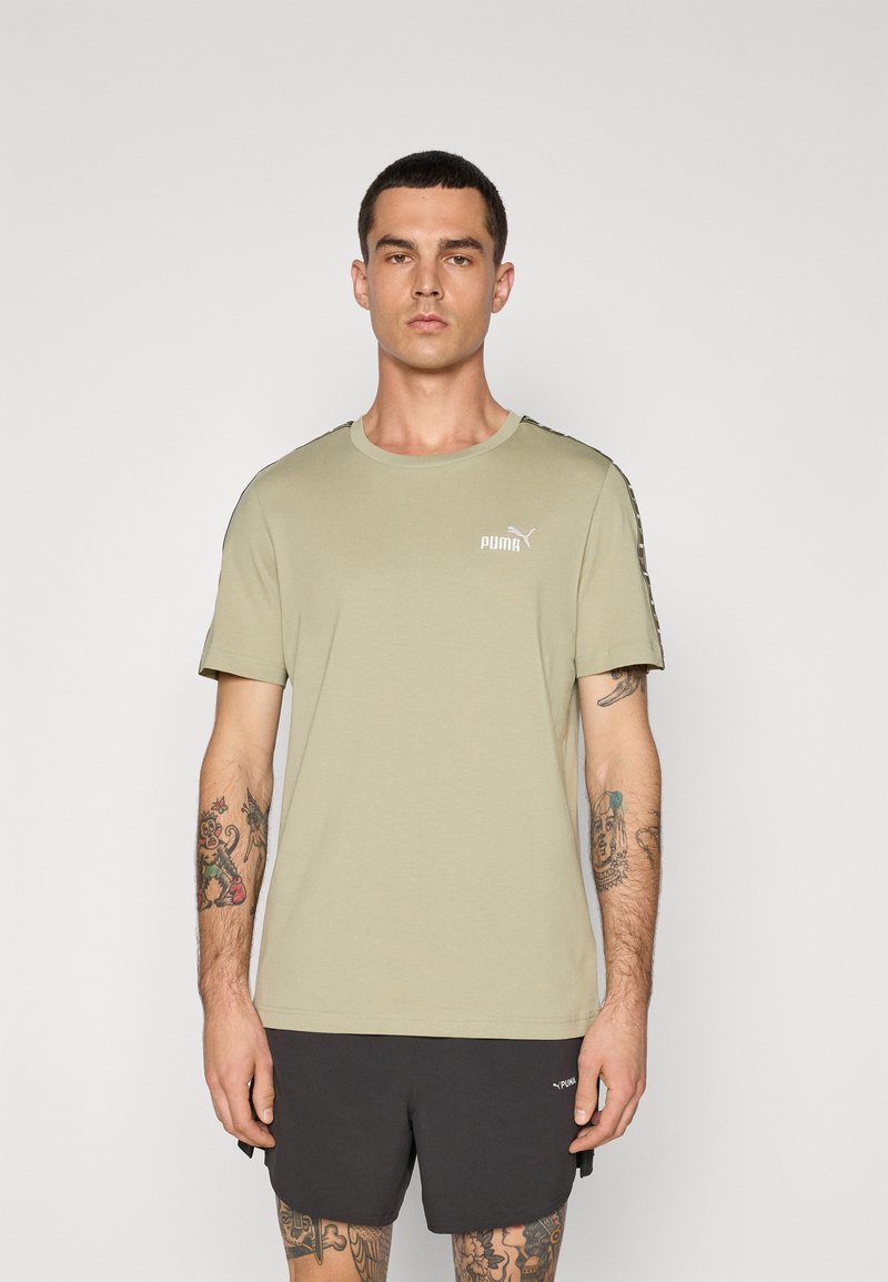 Olivgrünes T-Shirt mit kurzen Ärmeln aus Baumwolle, Rundhalsausschnitt, mit weißem Puma-Logo auf der Brust und gemusterten schwarzen Akzenten an den Ärmeln.