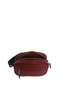 Bolso bandolera de cuero rojo con dos compartimentos con cremallera, herrajes plateados y correa ajustable negra. Textura suave y diseño compacto.