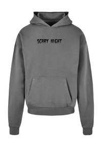 Felpa grigia con tasca frontale e cappuccio regolabile. Presenta il testo "SCARY NIGHT" in carattere nero, leggermente usurato, sul petto.