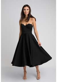 Czarna strapless sukienka midi z dekoltem w kształcie serca, rozkloszowanym dołem, gładkiego materiału oraz falbankami przy biuście.