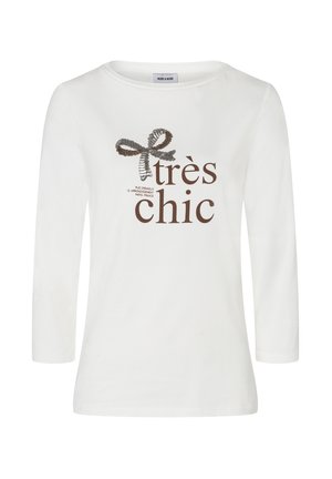 Weißes Langarmshirt mit Rundhalsausschnitt. Mit einem braunen Grafikdesign mit einer Schleife und dem Text "très chic" in fetter Schrift. Weiche Stofftextur.