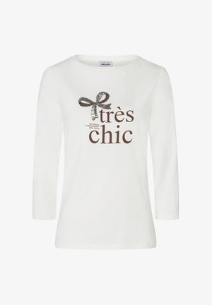 Weißes Langarmshirt mit Rundhalsausschnitt. Mit einem braunen Grafikdesign mit einer Schleife und dem Text "très chic" in fetter Schrift. Weiche Stofftextur.