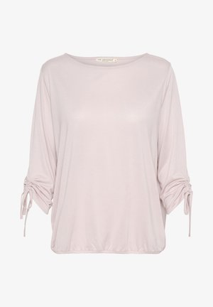 Gaiši rozā, brīvi pieguļošs tops ar apaļu izgriezumu, 3/4 piedurknēm un regulējamiem saitēm pie aprocēm. Maiga tekstūra ar brīvu formu.