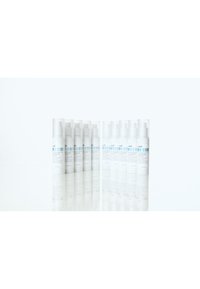 Ett set med tolv vita kosmetikaflaskor med subtil text, som har en klar etikett och en pumpdispenser, ordnade i två rader.