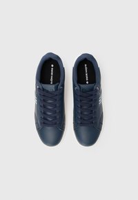 Ein Paar navyblaue Björn Borg Sneakers mit dunklen Schnürsenkeln, weißen Sohlen und dem Markenlogo auf den Zungen und Innensohlen.