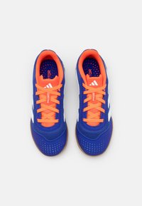 Blue athletic shoes with mesh upper, orange laces, and white accents. Designed with a textured sole and ventilation holes for breathability.