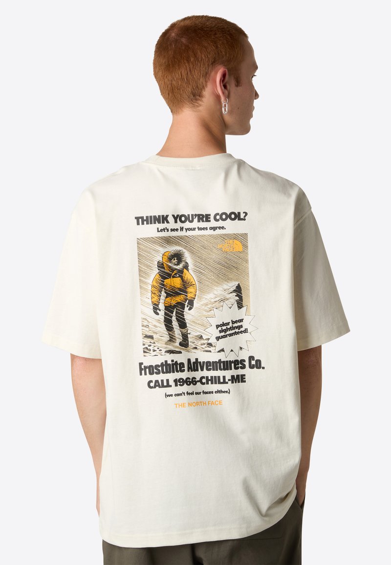 Kremowy t-shirt z grafiką z przodu i z tyłu. Z tyłu znajduje się kolorowy nadruk przedstawiający postać w żółtej parkach, wyrazisty tekst oraz zabawne akcenty.