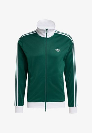 Veste de survêtement verte à fermeture éclair avec des accents blancs, dotée d'un col haut, de trois bandes blanches sur chaque manche et d'un petit logo sur la poitrine.