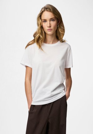 Witte katoenen T-shirt met korte mouwen, ronde hals en een losse pasvorm, gecombineerd met donkerbruine gestreepte broek.