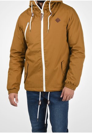 Bruine hoodie met witte rits, elastische manchetten en twee voorzakken. Voorzien van een diamantlogo op een patch en contrasterende trekkoorden.