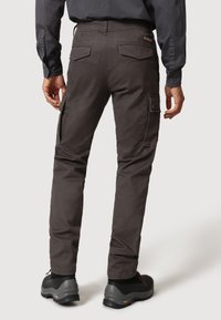Grå cargobyxor med sidofickor, tapered fit och förstärkt sömnad. Kombineras med svarta vandrarskor och en mörk skjorta.