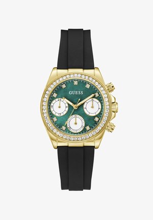 Montre-bracelet Guess ton or avec cadran vert, lunette en cristal, trois sous-cadrans et bracelet en silicone noir.
