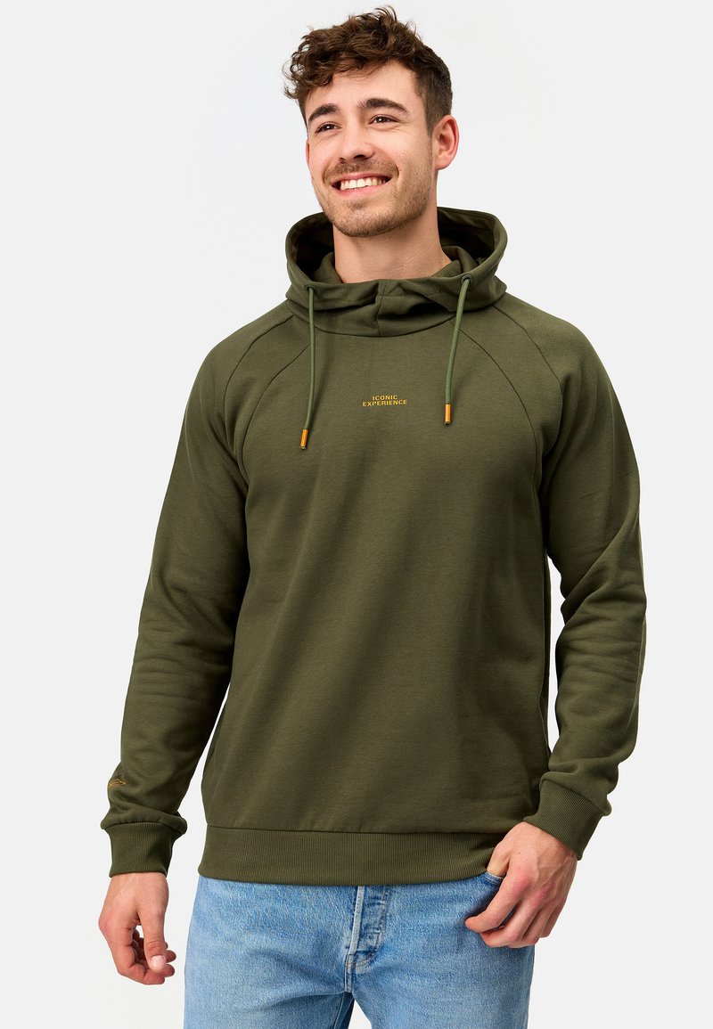 Sudadera con capucha de color verde oliva, con bolsillo tipo canguro, puños y dobladillo acanalados. Presenta un logo de texto dorado en el pecho y cordones de contraste.