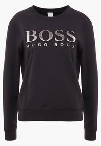 Svart sweatshirt i mjukt tyg med rund halsringning och långa ärmar. "BOSS"-logotyp i metallisk silver med "HUGO BOSS" i vitt under.