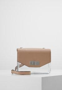 Sac en cuir couleur fauve avec un corps en plastique transparent, une quincaillerie argentée et une fermeture à rabat. Comprend une bandoulière détachable pour un port en travers du corps.