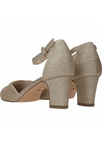 Glanzende gouden hakken met een ronde neus, enkelbandje en een gestructureerd oppervlak. De hakken zijn chunky en ongeveer vijf centimeter hoog.