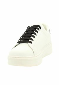 Sneakers in pelle bianca con suola spessa bianca, lacci neri e texture liscia. Presentano un sottile dettaglio laterale e un design a punta arrotondata.