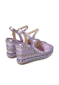 Lila wedge sandalen met een satijnen bovenwerk, kruislingse banden en gevlochten accenten. Decoratieve kralen sieren het platform en voegen textuur en detail toe.