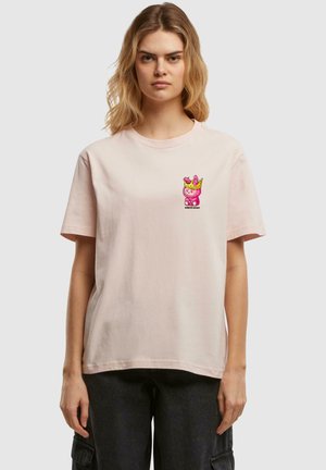 Ljusrosa bomulls-t-shirt med en färgglad broderad design av en tecknad karaktär med en krona på bröstet. Korts varvade ärmar, avslappnad passform.