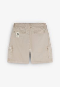 Pantaloni cargo beige realizzati in cotone, caratterizzati da una vestibilità regolare, due tasche posteriori, una tasca laterale e un'etichetta in tessuto con taglia 10.