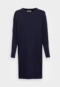 Robe-pull à manches longues en maille bleu marine avec un col rond et des manches côtelées, présentée sur un fond clair uni.