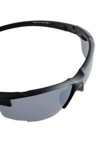 Melnas saulesbrilles ar ietverošu dizainu, pelēkas tonētas lēcas, elastīgu rāmi un teksturētām malām. Uz lentes iekšpuses atzīmēts "Ražots Ķīnā".