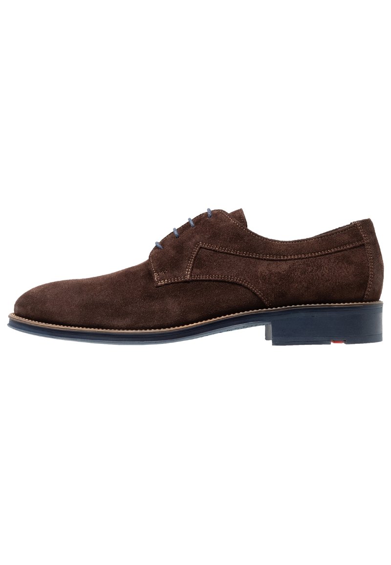 Chaussure habillée en daim marron avec un bout rond, des coutures minimalistes, des accents de lacets bleus et une semelle noire. Talon plat avec un détail de bord contrastant.