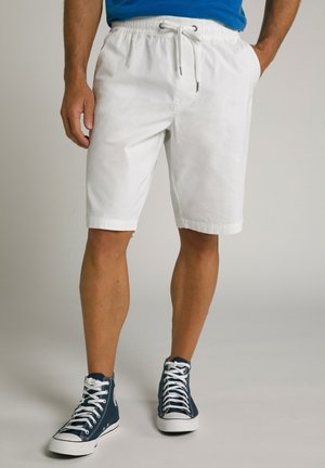 Hvide bomulds shorts med elastisk talje og snor, med sidelommer og opslagte kant, parret med marineblå høje sneakers.