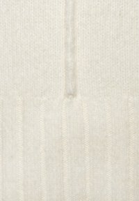 Cremfarbener Strickpullover mit gerippter Textur, ausgestattet mit einer zentralen Naht und weichem, flauschigem Material.