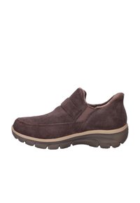 Chaussure marron en daim à enfiler avec intérieur rembourré, panneau latéral élastique et semelle épaisse en caoutchouc avec relief pour accroche.