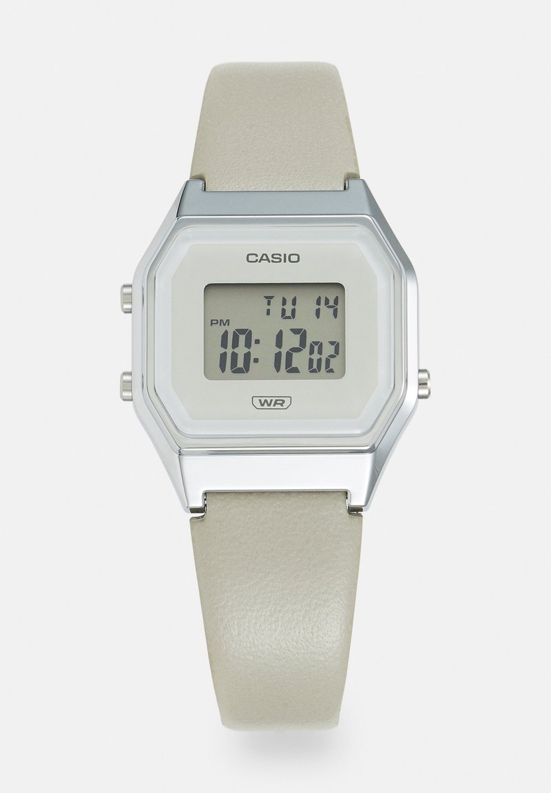 Montre numérique avec un boîtier rectangulaire en argent, un écran en plastique et un bracelet en cuir beige clair. Dispose d'un affichage de la date et d'une résistance à l'eau.