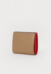 Kompaktowy portfel w brązowej skórze z czerwoną podszewką. Posiada gładką powierzchnię, zaokrąglone krawędzie oraz kontrastowe przeszycia wzdłuż szwów.
