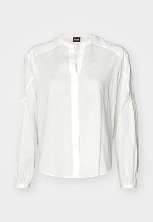 Weißes Hemd mit Knöpfen aus leichtem Stoff, mit Kragen, langen Ärmeln und lockerer Passform. Dezente Nahtdetails entlang der Schulternähte.