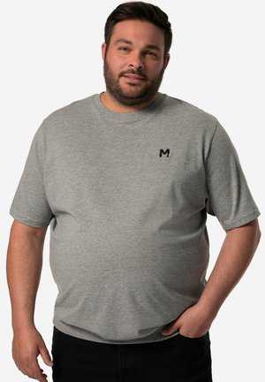 Camiseta de algodón gris claro con mangas cortas, cuello redondo y un pequeño logo negro en el pecho. Textura suave, ajuste relajado.