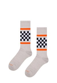Béžové ponožky s černo-bílým kostkovaným vzorem, lemované dvěma jasně oranžovými pruhy blízko vrchu.