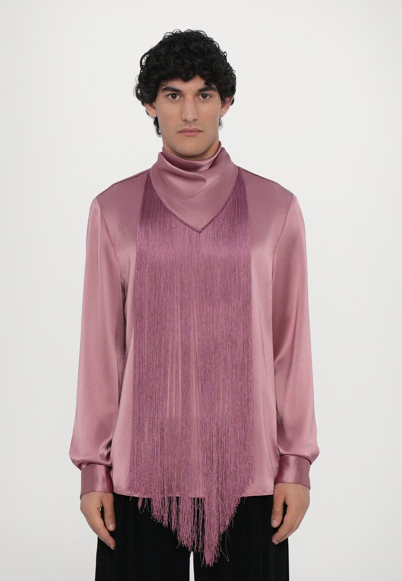 Blouse rose en satin avec un col haut et un long détail à franges à l'avant. Manches longues avec des poignets ajustés, texture lisse et coupe décontractée.