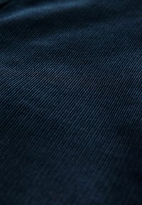 Țesătură de culoare bleumarin închis, cu o textură fină, cu nervuri verticale, prezentând o suprafață netedă și un model uniform pe întreaga suprafață.